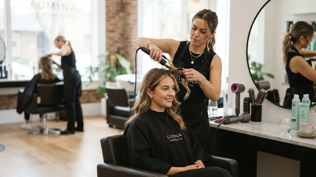 A professional hair stylist working in a salon to prevent humidity and environmental factors from ruining a hair set.