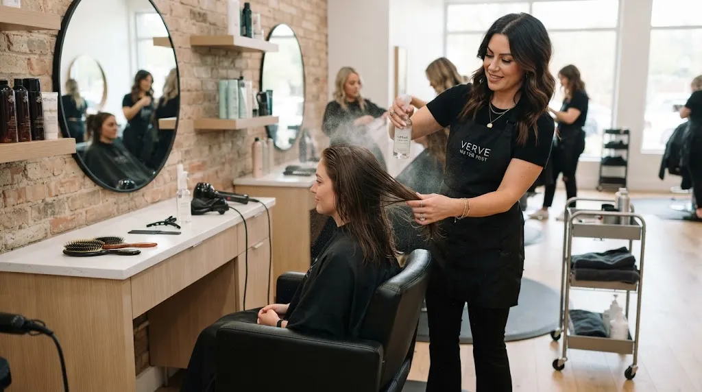 Professional stylist preparing and dampening hair with a spray bottle before styling and setting